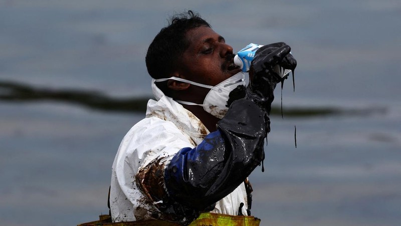 Pembersihan tumpahan minyak di Pantai Tanjong, Sentosa, Singapura, Selasa (18/6/2024). (REUTERS/Edgar Su)