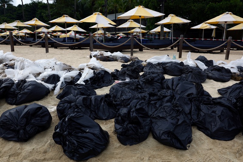 Pembersihan tumpahan minyak di Pantai Tanjong, Sentosa, Singapura, Selasa (18/6/2024). (REUTERS/Edgar Su) Pembersihan tumpahan minyak di Pantai Tanjong, Sentosa, Singapura, Selasa (18/6/2024). (REUTERS/Edgar Su)