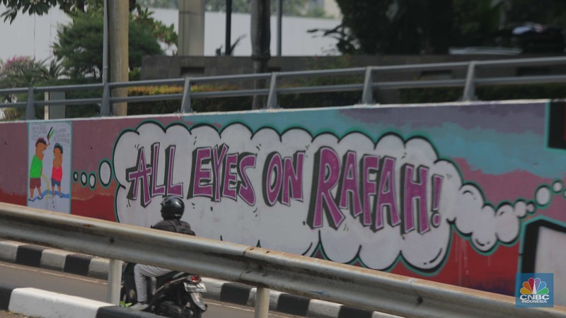 Pengendara sepeda motor melintasi mural dengan gambar wajah PM Israel, Benjamin Netanyahu dengan tulisan Stop Genocide di Kawasan Sudirman, Tanah Abang, Jakarta Pusat, Rabu (19/6/2024). Pengendara sepeda motor melintasi mural dengan gambar wajah PM Israel, Benjamin Netanyahu dengan tulisan Stop Genocide di Kawasan Sudirman, Tanah Abang, Jakarta Pusat, Rabu (19/6/2024). (CNBC Indonesia/Muhammad Sabki)