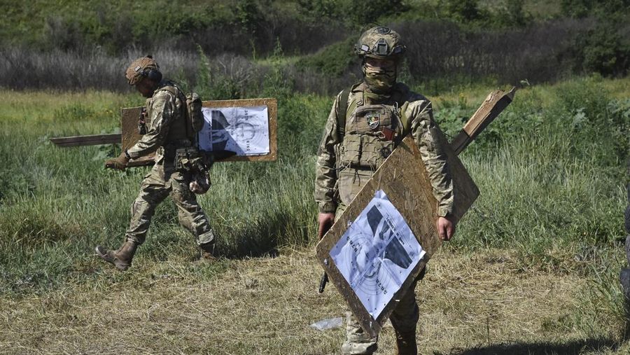 Seorang prajurit Ukraina dari brigade ke-141 berlatih menembak sasaran yang menggambarkan presiden Rusia Putin di garis depan di wilayah Zaporizhzhia, Ukraina, Selasa, 18 Juni 2024. (AP Photo/Andriy Andriyenko)