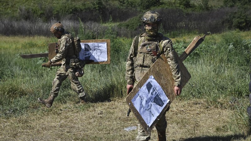 Seorang prajurit Ukraina dari brigade ke-141 berlatih menembak sasaran yang menggambarkan presiden Rusia Putin di garis depan di wilayah Zaporizhzhia, Ukraina, Selasa, 18 Juni 2024. (AP Photo/Andriy Andriyenko)