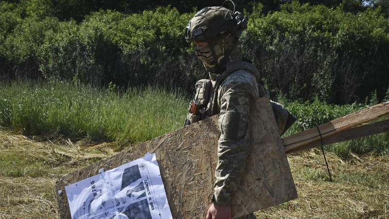 Seorang prajurit Ukraina dari brigade ke-141 berlatih menembak sasaran yang menggambarkan presiden Rusia Putin di garis depan di wilayah Zaporizhzhia, Ukraina, Selasa, 18 Juni 2024. (AP Photo/Andriy Andriyenko)