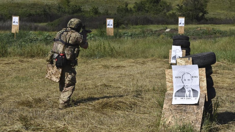 Seorang prajurit Ukraina dari brigade ke-141 berlatih menembak sasaran yang menggambarkan presiden Rusia Putin di garis depan di wilayah Zaporizhzhia, Ukraina, Selasa, 18 Juni 2024. (AP Photo/Andriy Andriyenko)