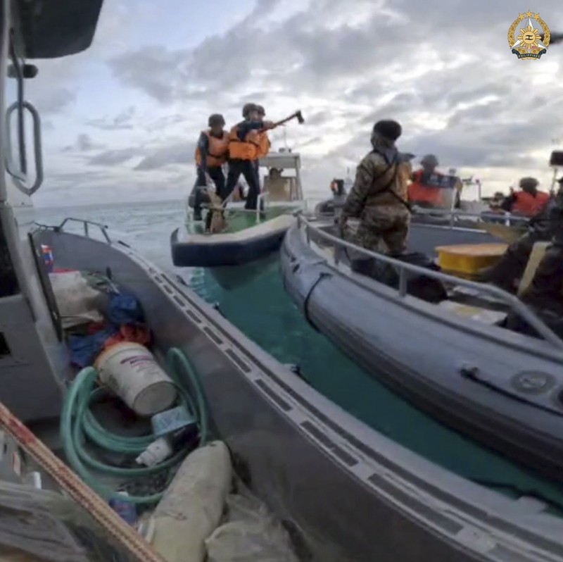 personel penjaga pantai Tiongkok (kiri, kanan) menaiki perahu karet mereka yang menghalangi angkatan laut Filipina perahu (C) selama konfrontasi di Second Thomas Shoal di Laut Cina Selatan. Personel penjaga pantai Tiongkok (kiri, kanan) menaiki perahu karet mereka yang menghalangi angkatan laut Filipina perahu (C) selama konfrontasi di Second Thomas Shoal di Laut Cina Selatan. (Photo by Handout / ARMED FORCES OF THE PHILIPPINES-PUBLIC AFFAIRS OFFICE / AFP)