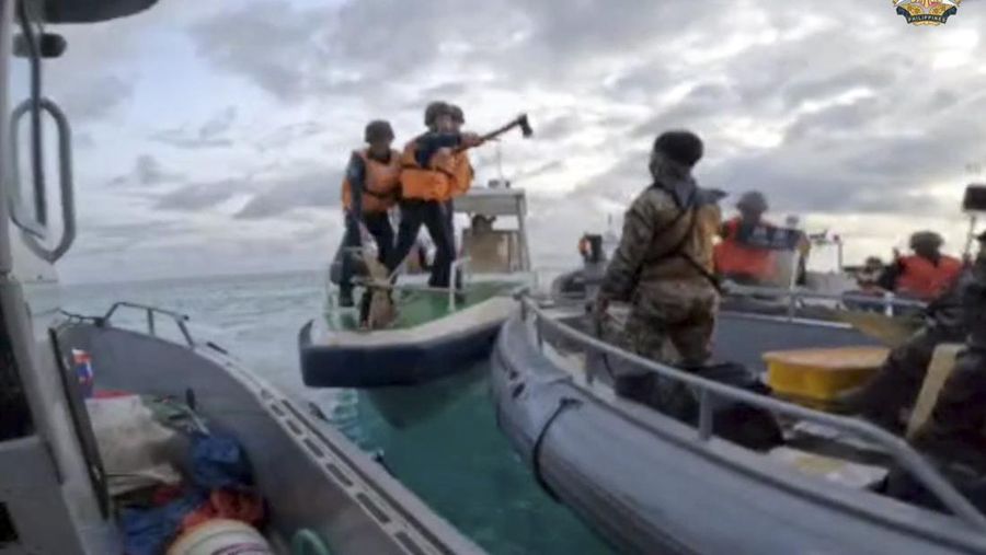 Personel penjaga pantai Tiongkok (kiri, kanan) menaiki perahu karet mereka yang menghalangi angkatan laut Filipina perahu (C) selama konfrontasi di Second Thomas Shoal di Laut Cina Selatan. (Photo by Handout / ARMED FORCES OF THE PHILIPPINES-PUBLIC AFFAIRS OFFICE / AFP)