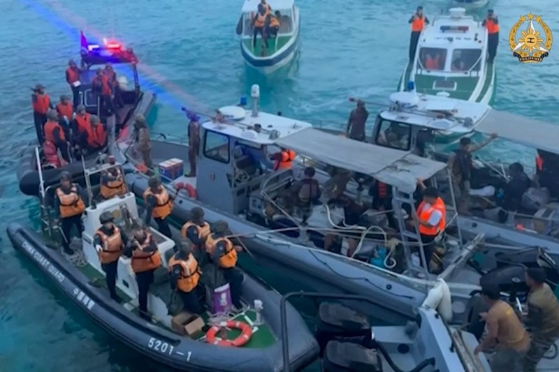 Personel penjaga pantai Tiongkok (kiri, kanan) menaiki perahu karet mereka yang menghalangi angkatan laut Filipina perahu (C) selama konfrontasi di Second Thomas Shoal di Laut Cina Selatan. (Photo by Handout / ARMED FORCES OF THE PHILIPPINES-PUBLIC AFFAIRS OFFICE / AFP)