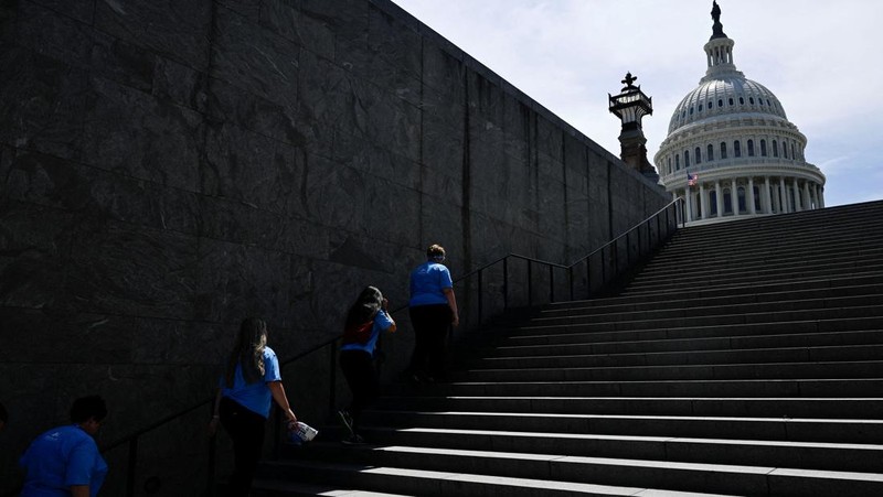Seorang pria menutupi wajahnya menggunakan kain untuk melindungi dirinya dari sinar matahari saat dia memeriksa rel kereta api pada hari musim panas di New Delhi, India, 18 Juni 2024. (REUTERS/Priyanshu Singh)