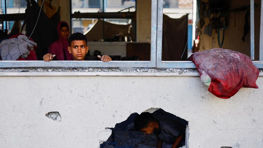 Pengungsi Palestina berlindung di Sekolah PBB, yang rusak akibat serangan udara Israel, di tengah konflik Israel-Hamas, di Khan Younis, di selatan Jalur Gaza, 20 Juni 2024. (REUTERS/Doaa Mohammed)