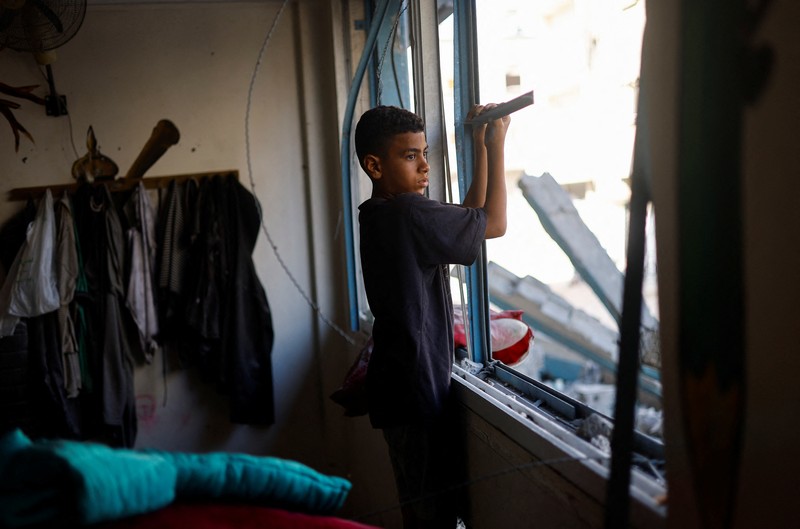 Pengungsi Palestina berlindung di Sekolah PBB, yang rusak akibat serangan udara Israel, di tengah konflik Israel-Hamas, di Khan Younis, di selatan Jalur Gaza, 20 Juni 2024. (REUTERS/Doaa Mohammed)