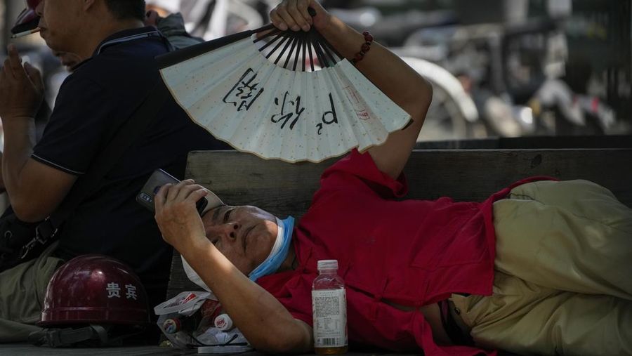 Seorang pria menutupi wajahnya menggunakan kain untuk melindungi dirinya dari sinar matahari saat dia memeriksa rel kereta api pada hari musim panas di New Delhi, India, 18 Juni 2024. (REUTERS/Priyanshu Singh)
