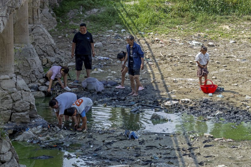 Warga Beijing menggunakan pelindung wajah saat beraktivitas diluar rumah di tengah cuaca panas ekstrem. (AP Photo/Andy Wong) Warga Beijing menggunakan pelindung wajah saat beraktivitas diluar rumah di tengah cuaca panas ekstrem. (AP Photo/Andy Wong)