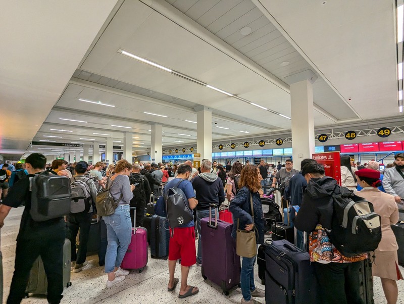 Penumpang mengantri di luar Terminal 1 setelah pemadaman listrik semalaman menyebabkan gangguan dan pembatalan di Bandara Manchester di Manchester, Inggris, 23 Juni 2024. (REUTERS/Phil Noble)