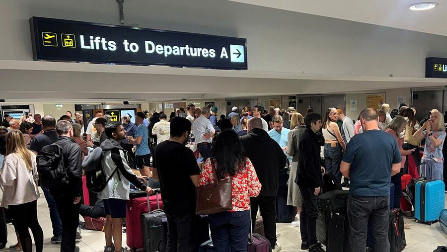 Penumpang mengantri di luar Terminal 1 setelah pemadaman listrik semalaman menyebabkan gangguan dan pembatalan di Bandara Manchester di Manchester, Inggris, 23 Juni 2024. (REUTERS/Phil Noble)