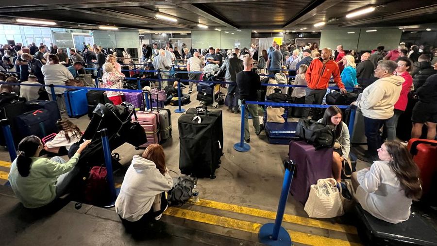 Penumpang mengantri di luar Terminal 1 setelah pemadaman listrik semalaman menyebabkan gangguan dan pembatalan di Bandara Manchester di Manchester, Inggris, 23 Juni 2024. (REUTERS/Phil Noble)