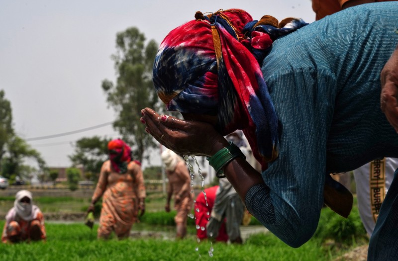 Seorang pria menutupi wajahnya menggunakan kain untuk melindungi dirinya dari sinar matahari saat dia memeriksa rel kereta api pada hari musim panas di New Delhi, India, 18 Juni 2024. (REUTERS/Priyanshu Singh)