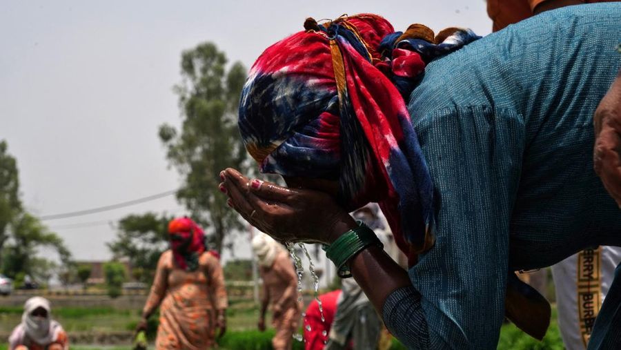 Seorang pria menutupi wajahnya menggunakan kain untuk melindungi dirinya dari sinar matahari saat dia memeriksa rel kereta api pada hari musim panas di New Delhi, India, 18 Juni 2024. (REUTERS/Priyanshu Singh)