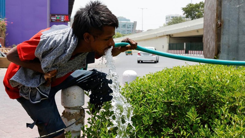 Seorang pria menutupi wajahnya menggunakan kain untuk melindungi dirinya dari sinar matahari saat dia memeriksa rel kereta api pada hari musim panas di New Delhi, India, 18 Juni 2024. (REUTERS/Priyanshu Singh)