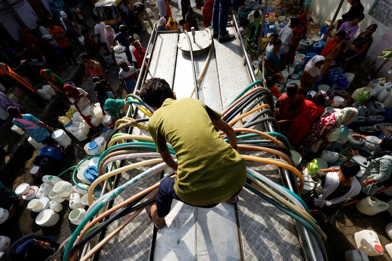 Seorang pria menutupi wajahnya menggunakan kain untuk melindungi dirinya dari sinar matahari saat dia memeriksa rel kereta api pada hari musim panas di New Delhi, India, 18 Juni 2024. (REUTERS/Priyanshu Singh)