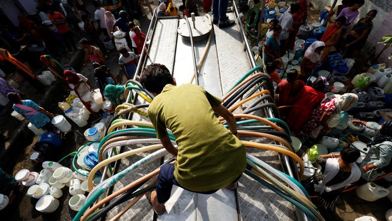 Seorang pria menutupi wajahnya menggunakan kain untuk melindungi dirinya dari sinar matahari saat dia memeriksa rel kereta api pada hari musim panas di New Delhi, India, 18 Juni 2024. (REUTERS/Priyanshu Singh)