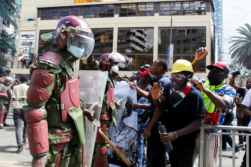Demonstrators react as police stand guard during a demonstration against Kenya's proposed finance bill 2024/2025 in Nairobi, Kenya, June 25, 2024. REUTERS/Monicah Mwangi