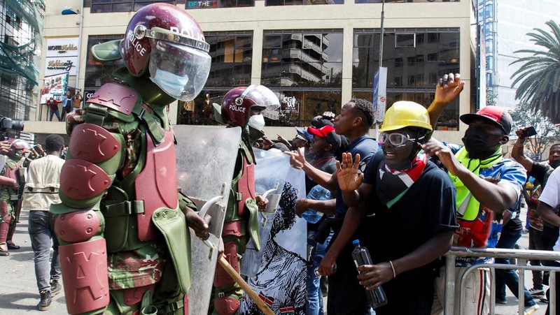 Demonstrators react as police stand guard during a demonstration against Kenya's proposed finance bill 2024/2025 in Nairobi, Kenya, June 25, 2024. REUTERS/Monicah Mwangi