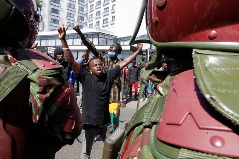 Demonstrators react as police stand guard during a demonstration against Kenya's proposed finance bill 2024/2025 in Nairobi, Kenya, June 25, 2024. REUTERS/Monicah Mwangi