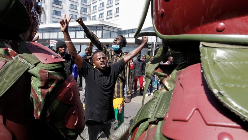Demonstrators react as police stand guard during a demonstration against Kenya's proposed finance bill 2024/2025 in Nairobi, Kenya, June 25, 2024. REUTERS/Monicah Mwangi