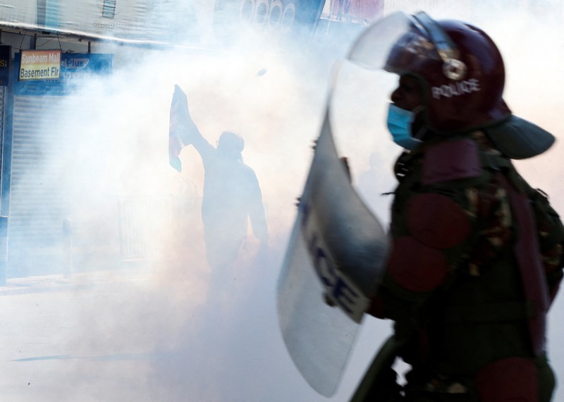 Demonstrators react as police stand guard during a demonstration against Kenya's proposed finance bill 2024/2025 in Nairobi, Kenya, June 25, 2024. REUTERS/Monicah Mwangi