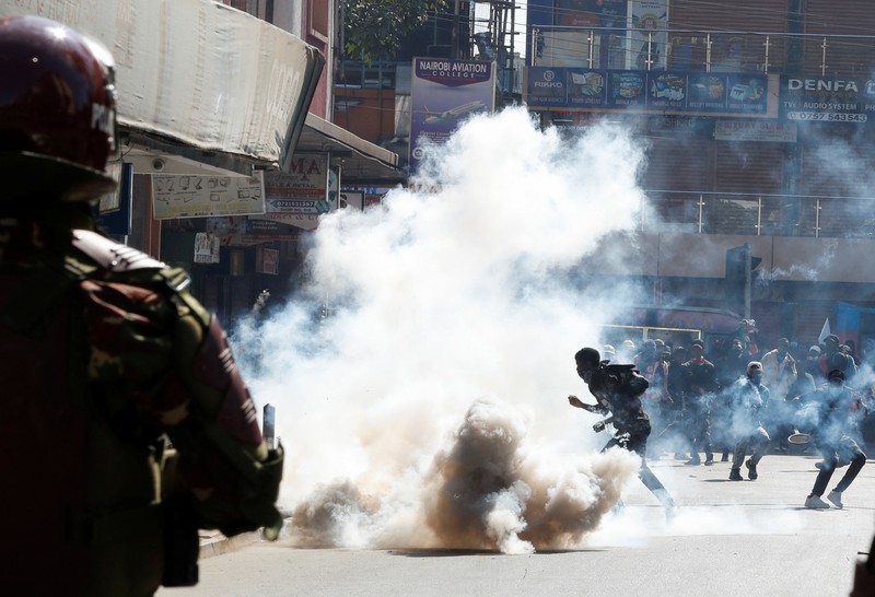 Demonstrators react as police stand guard during a demonstration against Kenya's proposed finance bill 2024/2025 in Nairobi, Kenya, June 25, 2024. REUTERS/Monicah Mwangi