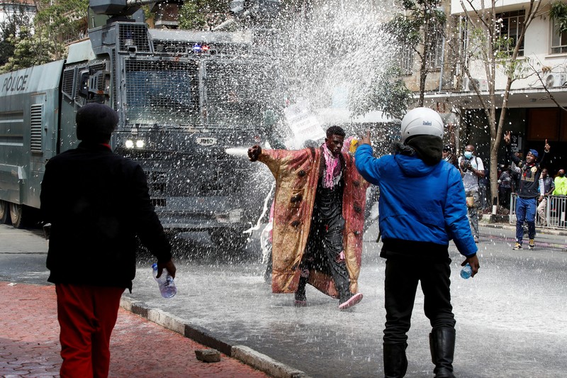 Demonstrators react as police stand guard during a demonstration against Kenya's proposed finance bill 2024/2025 in Nairobi, Kenya, June 25, 2024. REUTERS/Monicah Mwangi