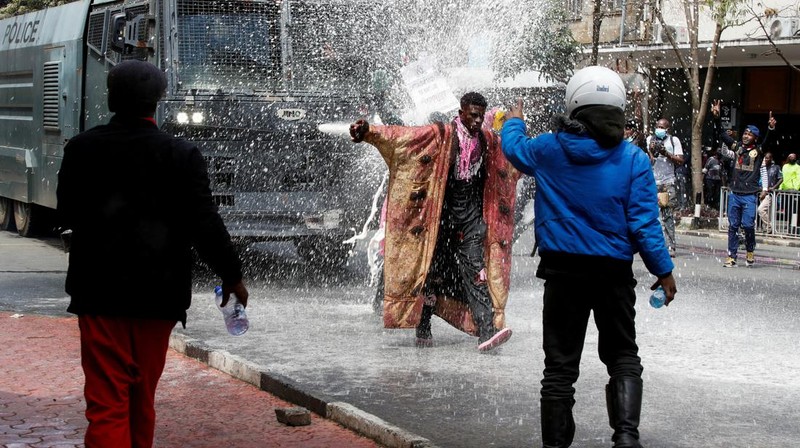 Demonstrators react as police stand guard during a demonstration against Kenya's proposed finance bill 2024/2025 in Nairobi, Kenya, June 25, 2024. REUTERS/Monicah Mwangi