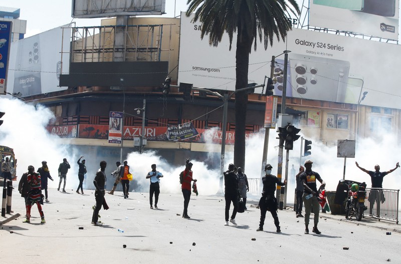 Demonstrators react as police stand guard during a demonstration against Kenya's proposed finance bill 2024/2025 in Nairobi, Kenya, June 25, 2024. REUTERS/Monicah Mwangi
