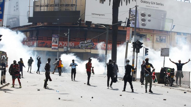 Demonstrators react as police stand guard during a demonstration against Kenya's proposed finance bill 2024/2025 in Nairobi, Kenya, June 25, 2024. REUTERS/Monicah Mwangi