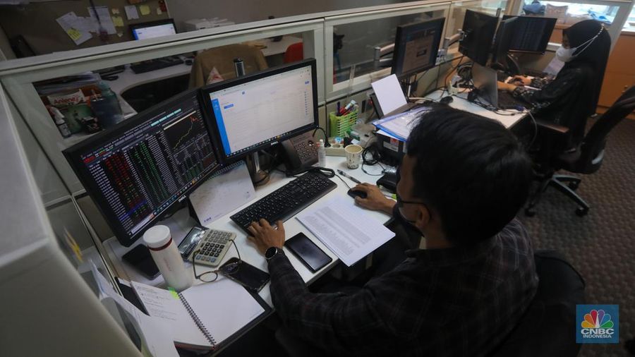 Pekerja memantau pergerakan Indeks Harga Saham Gabungan (IHSG) pada salah satu kantor Sekuritas di Jakarta, Selasa (25/6/2024). (CNBC Indonesia/Faisal Rahman))