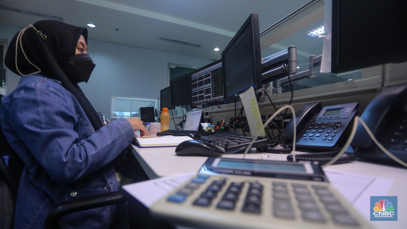 Pekerja memantau pergerakan Indeks Harga Saham Gabungan (IHSG) pada salah satu kantor Sekuritas di Jakarta, Selasa (25/6/2024). (CNBC Indonesia/Faisal Rahman))