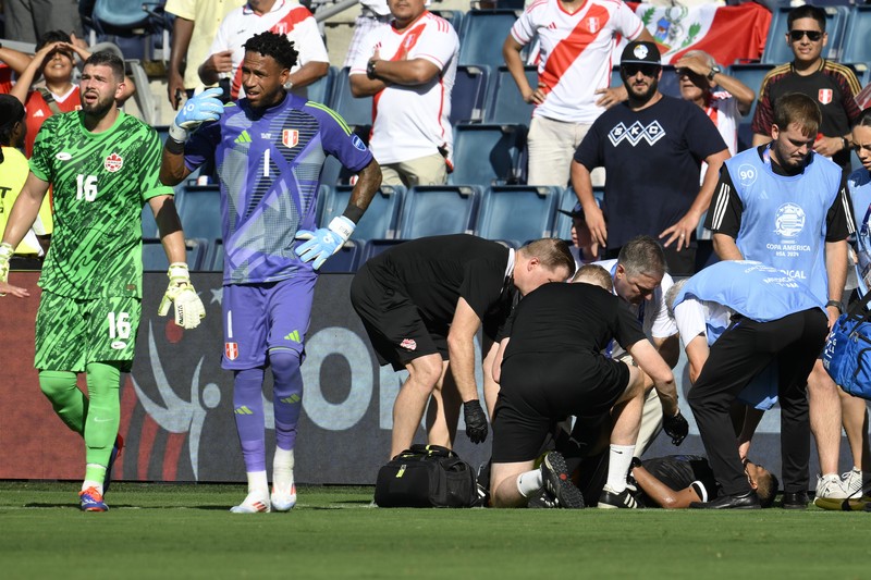 Kiper Kanada Maxime Crepeau, rekan setimnya Liam Millar, kanan, dan wasit Mario Escobar, dari Guatemala, merawat asisten wasit Humberto Panjoj setelah ia pingsan saat pertandingan sepak bola Grup A Copa America di Kansas City, Kansas, Selasa, 25 Juni 2024 . Kiper Kanada Maxime Crepeau, rekan setimnya Liam Millar, kanan, dan wasit Mario Escobar, dari Guatemala, merawat asisten wasit Humberto Panjoj setelah ia pingsan saat pertandingan sepak bola Grup A Copa America di Kansas City, Kansas, Selasa, 25 Juni 2024 . (AP Photo/Ed Zurga)
