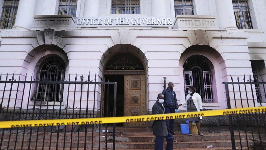 Nairobi county workers stand in front of the governor's office, which was burned during yesterday's protest over proposed tax hikes in a finance bill in downtown Nairobi, Kenya Wednesday, June 26, 2024. Thousands of protesters stormed and burned a section of Kenya's parliament Tuesday to protest tax proposals. Police responded with gunfire and several protesters were killed. (AP Photo/Brian Inganga)