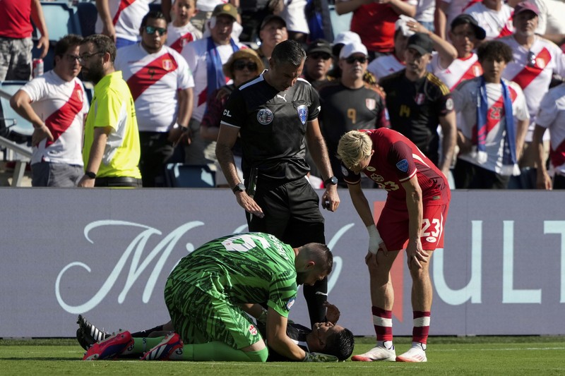 Kiper Kanada Maxime Crepeau, rekan setimnya Liam Millar, kanan, dan wasit Mario Escobar, dari Guatemala, merawat asisten wasit Humberto Panjoj setelah ia pingsan saat pertandingan sepak bola Grup A Copa America di Kansas City, Kansas, Selasa, 25 Juni 2024 . Kiper Kanada Maxime Crepeau, rekan setimnya Liam Millar, kanan, dan wasit Mario Escobar, dari Guatemala, merawat asisten wasit Humberto Panjoj setelah ia pingsan saat pertandingan sepak bola Grup A Copa America di Kansas City, Kansas, Selasa, 25 Juni 2024 . (AP Photo/Ed Zurga)