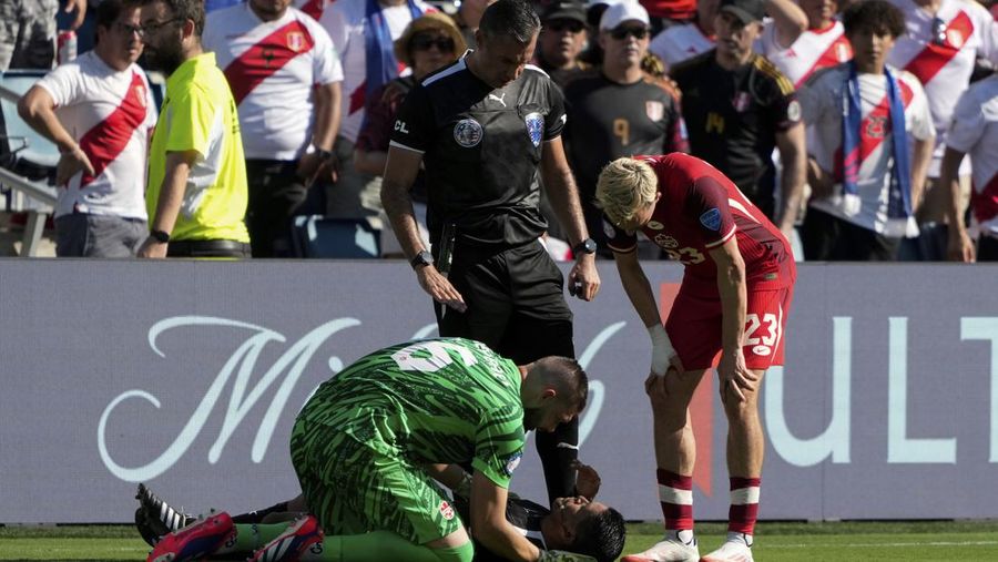 Kiper Kanada Maxime Crepeau, rekan setimnya Liam Millar, kanan, dan wasit Mario Escobar, dari Guatemala, merawat asisten wasit Humberto Panjoj setelah ia pingsan saat pertandingan sepak bola Grup A Copa America di Kansas City, Kansas, Selasa, 25 Juni 2024 . (AP Photo/Ed Zurga)