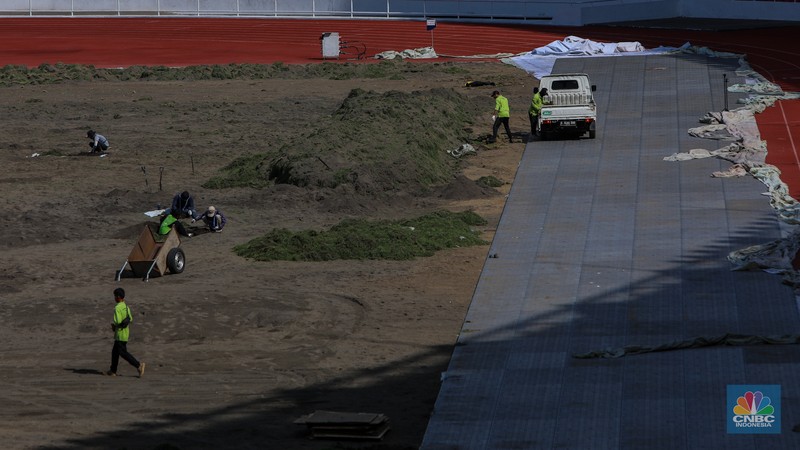 Pekerja melakukan pembongkaran rumput lapangan di Stadion Utama Gelora Bung Karno (SUGBK), Senayan, Jakarta, Rabu (26/6/2024).  (CNBC Indonesia/Faisal Rahman)