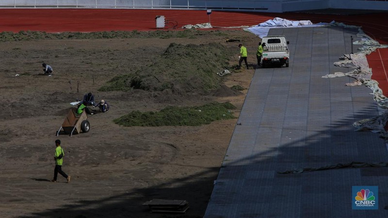 Pekerja melakukan pembongkaran rumput lapangan di Stadion Utama Gelora Bung Karno (SUGBK), Senayan, Jakarta, Rabu (26/6/2024).  (CNBC Indonesia/Faisal Rahman)