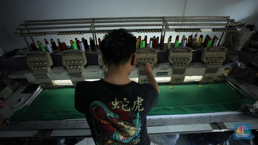 Penjahit menyelesaikan pembuatan baju seragam sekolah di sebuah industri rumahan di kawasan Jakarta, Rabu (26/6/2024).  (CNBC Indonesia/Tri Susilo)