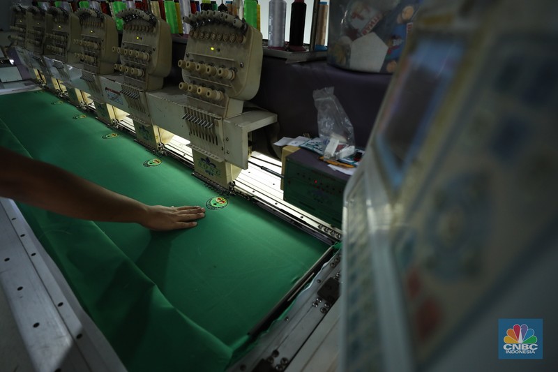 Penjahit menyelesaikan pembuatan baju seragam sekolah di sebuah industri rumahan di kawasan Jakarta, Rabu (26/6/2024).  (CNBC Indonesia/Tri Susilo)