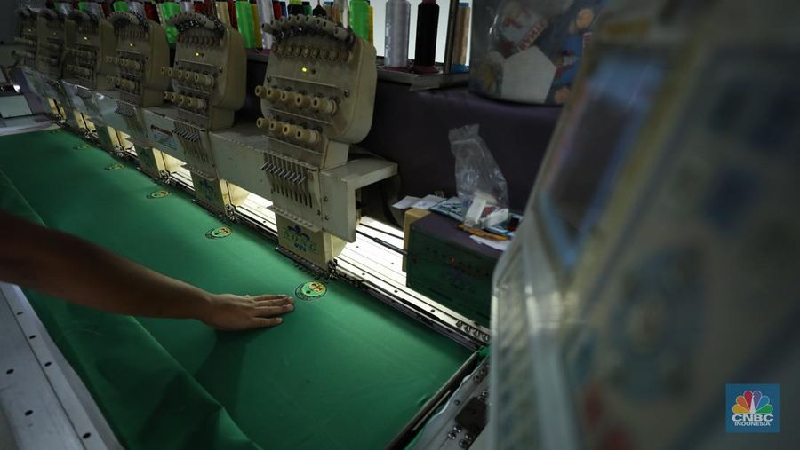 Penjahit menyelesaikan pembuatan baju seragam sekolah di sebuah industri rumahan di kawasan Jakarta, Rabu (26/6/2024).  (CNBC Indonesia/Tri Susilo)