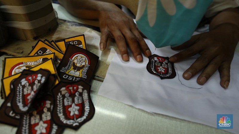 Penjahit menyelesaikan pembuatan baju seragam sekolah di sebuah industri rumahan di kawasan Jakarta, Rabu (26/6/2024).  (CNBC Indonesia/Tri Susilo)