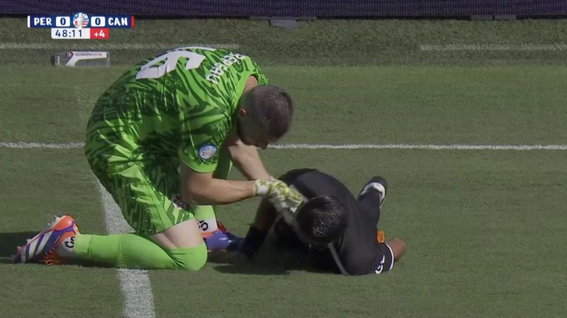Kiper Kanada Maxime Crepeau, rekan setimnya Liam Millar, kanan, dan wasit Mario Escobar, dari Guatemala, merawat asisten wasit Humberto Panjoj setelah ia pingsan saat pertandingan sepak bola Grup A Copa America di Kansas City, Kansas, Selasa, 25 Juni 2024 . (AP Photo/Ed Zurga)