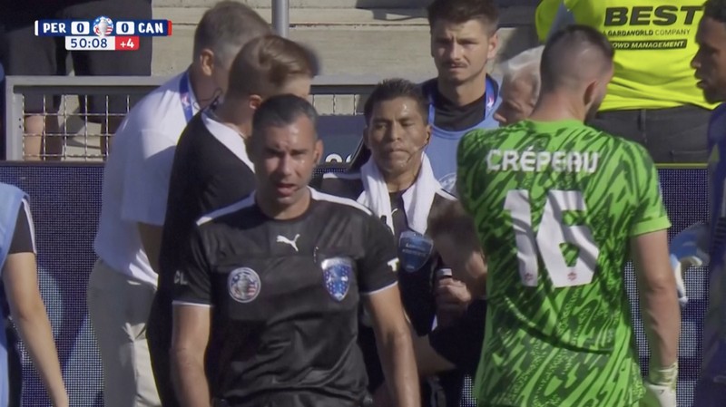 Kiper Kanada Maxime Crepeau, rekan setimnya Liam Millar, kanan, dan wasit Mario Escobar, dari Guatemala, merawat asisten wasit Humberto Panjoj setelah ia pingsan saat pertandingan sepak bola Grup A Copa America di Kansas City, Kansas, Selasa, 25 Juni 2024 . (AP Photo/Ed Zurga)