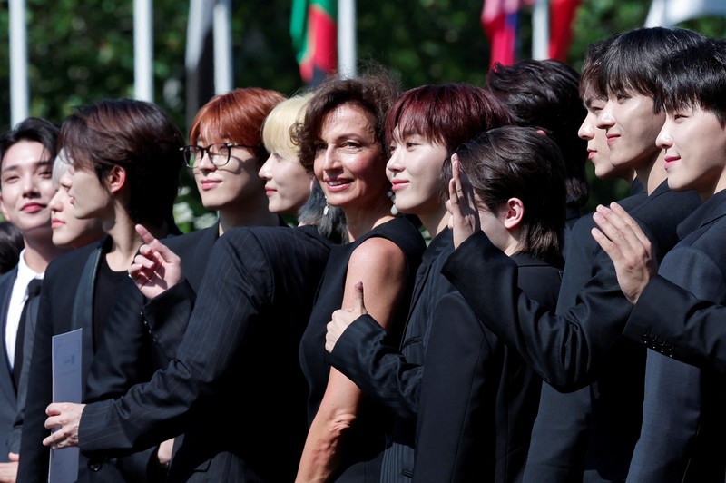 Direktur Jenderal UNESCO Audrey Azoulay dan anggota boy band Korea Selatan SEVENTEEN berpose tiba untuk menghadiri sesi pemotretan sebelum upacara pencalonan mereka sebagai Duta Besar Pemuda di kantor pusat UNESCO di Paris, Prancis, 26 Juni 2024. (REUTERS/Gonzalo Fuentes)