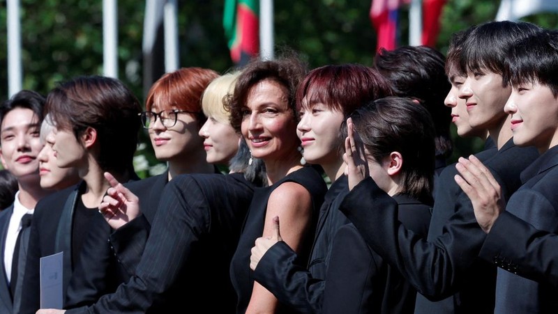 Direktur Jenderal UNESCO Audrey Azoulay dan anggota boy band Korea Selatan SEVENTEEN berpose tiba untuk menghadiri sesi pemotretan sebelum upacara pencalonan mereka sebagai Duta Besar Pemuda di kantor pusat UNESCO di Paris, Prancis, 26 Juni 2024. (REUTERS/Gonzalo Fuentes)