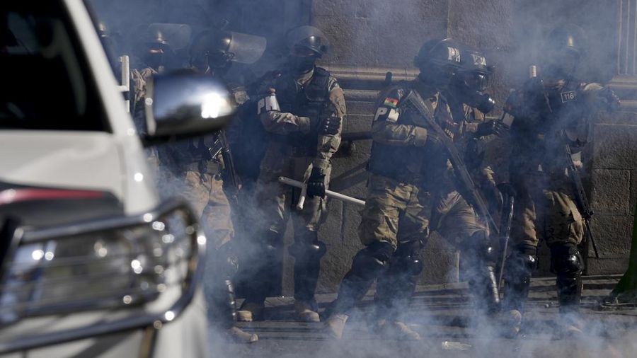 Polisi Militer berdiri di tengah gas air mata yang mereka tembakkan di luar istana presiden di Plaza Murillo di La Paz, Bolivia, Rabu, 26 Juni 2024. (AP Photo/Juan Karita)